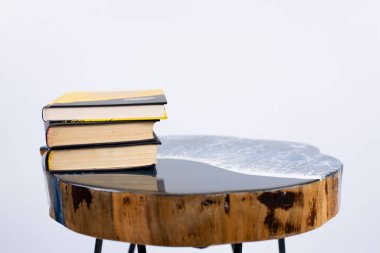 Epoksi reçineden yapılmış bir masa. Dekoratif ahşap masa. Mobilyalar. Kitaplar masaya..