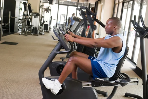 Man Exercising On Stationary Cycle — Stock Photo, Image