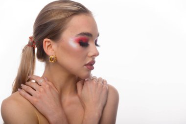Bayan portresi. Mavi gözlü ve dolgun dudaklı bir model için profesyonel makyaj. Kırmızı ruj, renkli dumanlı gözler. Beyaz bir arka planda izole edilmiş. Metin için boşluk