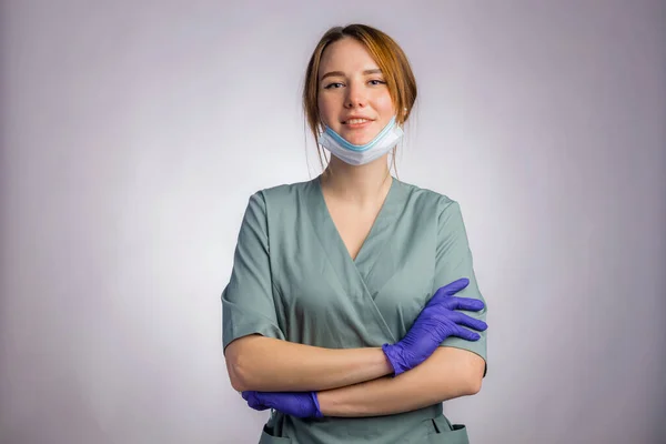 肖像若いです自信のある女性医師で統一医療面マスクとラテックス医療手袋上の灰色の背景 — ストック写真