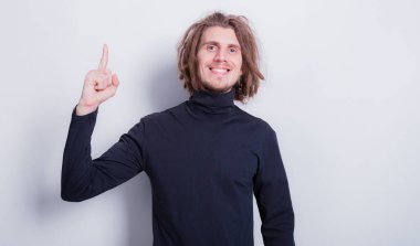 Gri arkaplan fotokopi alanı üzerine fikir üreten, rastalı saçlı komik yüzlü genç adam.