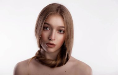 Beyaz arka plan fotokopi alanına dolanmış uzun saçlı sevimli ve güzel bir genç kadın. Kafa ve saç bakım ve sağlık konsepti