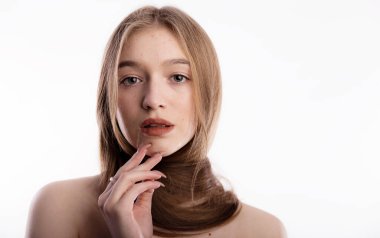 Alnında sivilce olan genç bir kadın. Beyaz arka plan fotokopi alanına sarılmış uzun saçlar.