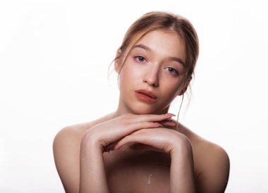 Güzel, genç bir kadın yüzü. Taze, temiz ciltli, kameraya bakan güzel sarışın kadın portresi. Beyaz arka planda izole edilmiş. Güzel, kaplıca ve cilt bakımı konsepti.