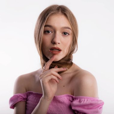 Boynuna dolanmış uzun saçlı genç bir kadın beyaz arka plan fotokopi alanına elini sürerek dudaklarına bastırıyor. Kafa ve saç bakım ve sağlık konsepti