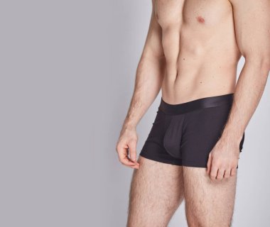 Beyaz arka planda izole edilmiş iç çamaşırı giyen kaslı bir genç. Erkekler için iç çamaşırı kopyalama alanı. Yazdırma ya da dizayn şablonu için bir model. Temel giyim tarzı. Logo yok.