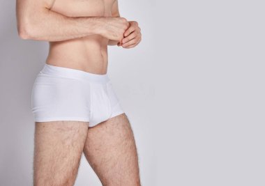 Beyaz arka planda izole edilmiş iç çamaşırı giyen kaslı bir genç. Erkekler için iç çamaşırı kopyalama alanı. Yazdırma ya da dizayn şablonu için bir model. Temel giyim tarzı. Logo yok.