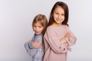 En iyi arkadaşlar ya da kız kardeşler birlikte mutlular. Birbirlerine yakın duruyorlar. Arkadaşlarının omuzlarında dinleniyorlar. Gülümseyen kızlar örgü kazak giyer ve arkadaşının omzuna yaslanır.