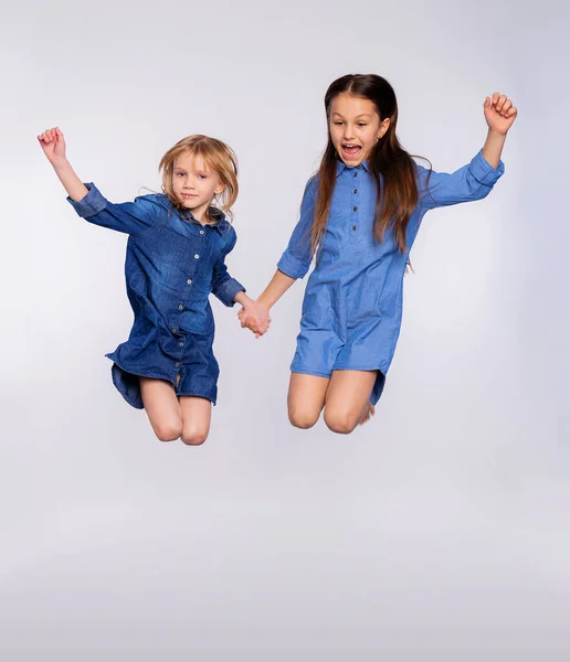 2人の興奮した可愛い子供たちのフルサイズの肖像画は 灰色の背景に隔離されたオープン口をジャンプ楽しむ 愛する姉妹や友人が遊びや楽しみを持ってジャンプ — ストック写真