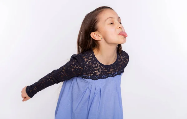 子供の面白い女の子のお茶を回避し 白の背景に隔離された舌を示しています 顔の表情 — ストック写真