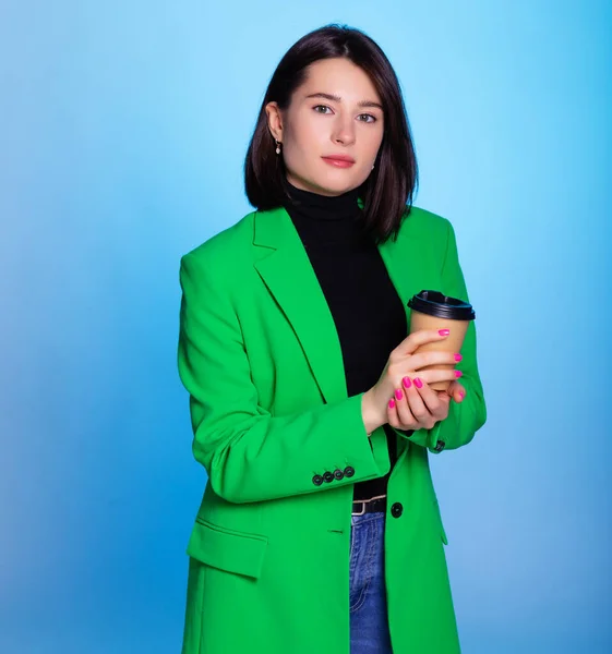 Yeşil Ceket Giymiş Elinde Kahve Mavi Arka Planda Izole Edilmiş — Stok fotoğraf