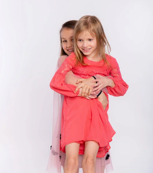 2つの幸せな親友や姉妹の子供の女の子抱擁 白を背景に楽しさと感情を持ち 笑顔で 友情と関係のライフスタイルの人々のコンセプト — ストック写真