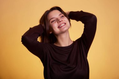 Sarı arka plan stüdyo resminde yalnız bırakılmış süveter giyen genç esmer kadın. İnsanlar samimi duygular, yaşam tarzı konsepti. Kopyalama alanı oluştur.