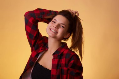 At kuyruğunu elinde tutan genç bir kadın. Saç bakımı ya da diğer güzellik konseptleri için kullanılabilir. Saç bakım ürünleri reklamı.