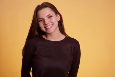 Sarı arka plan stüdyo resminde yalnız bırakılmış süveter giyen genç esmer kadın. İnsanlar samimi duygular, yaşam tarzı konsepti. Kopyalama alanı oluştur.