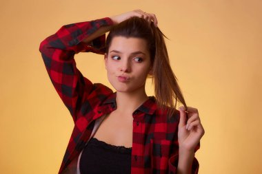 At kuyruğunu elinde tutan genç bir kadın. Saç bakımı ya da diğer güzellik konseptleri için kullanılabilir. Saç bakım ürünleri reklamı.