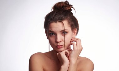 Genç kadın problem teni. Sivilce, sivilce, temiz ve temiz, yağlı, kuru deri konsepti. Endişeli genç bayanın beyaz arka planda yüzüne nazikçe dokunmasından kurtul.