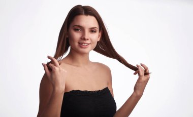 Siyah kolsuz, beyaz arka planda spor kıyafetleri olan düz saçlı hoş bir fitness kadını. Sıradan görünüş