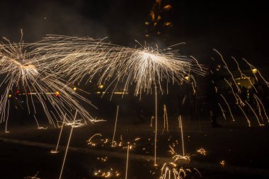 Barselona, Katalonya İspanya - 24.09.2021: Geleneksel yangın gösterisi, ünlü Fiestas de Gracia 'nın finali, yerel halk ve turistler için favori eğlence merkezi. İnsanlar şeytan gibi giyinip havai fişek attılar.