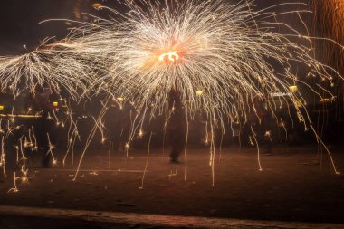 Barselona, Katalonya İspanya - 24.09.2021: Geleneksel yangın gösterisi, ünlü Fiestas de Gracia 'nın finali, yerel halk ve turistler için favori eğlence merkezi. İnsanlar şeytan gibi giyinip havai fişek attılar.