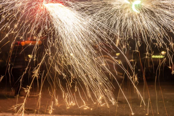 Barselona, Katalonya İspanya - 24.09.2021: Geleneksel yangın gösterisi, ünlü Fiestas de Gracia 'nın finali, yerel halk ve turistler için favori eğlence merkezi. İnsanlar şeytan gibi giyinip havai fişek attılar.