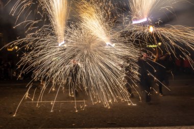 Barselona, Katalonya İspanya - 24.09.2021: Geleneksel yangın gösterisi, ünlü Fiestas de Gracia 'nın finali, yerel halk ve turistler için favori eğlence merkezi. İnsanlar şeytan gibi giyinip havai fişek attılar.