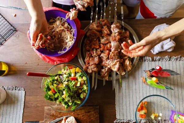 Family or friends prepare barbecue in their kitchen. Assorted delicious barbecue with meat and vegetable