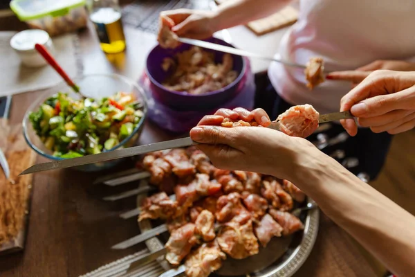 Family or friends prepare barbecue in their kitchen. Assorted delicious barbecue with meat and vegetable