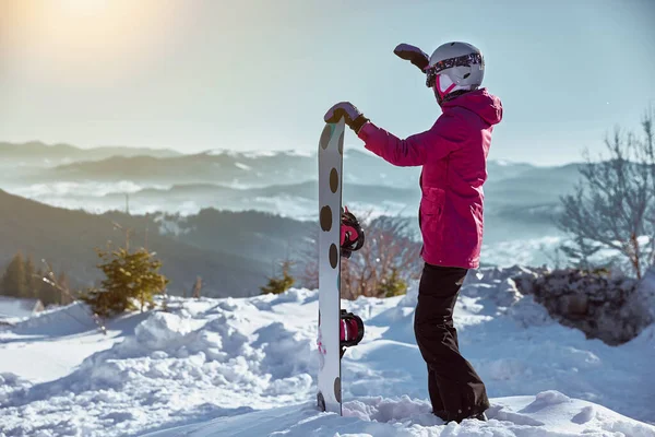 太陽の光の下でスキー場の上に眠っている機器ヘルメットやゴーグル外部保持スノーボードを持つ女性スノーボーダー 晴れた冬の日のカルパティアで山の上 ウクライナだ フリースペースあなたのためのテキスト — ストック写真