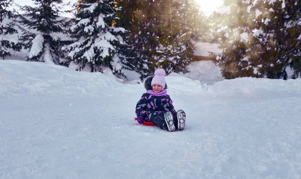 Küçük Kız Kış Kızağının Tadını Çıkarıyor Karlı Bir Tepede Oynayan — Stok fotoğraf
