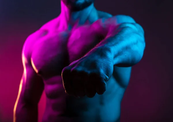 健美男子在五彩缤纷的霓虹灯下露出拳头 裸露肌肉躯干 腹肌在霓虹灯下聚焦拳头 — 图库照片