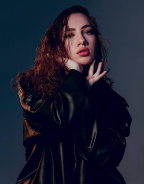 Artı siyah deri ceketli, cüsseli kadın. Güzel kıvrımlı vücut, iç çamaşırlarıyla poz veren baştan çıkarıcı kadın. Koyu mavi stüdyo arka planında duran iç çamaşırlı çekici, iri yarı bir kadın..