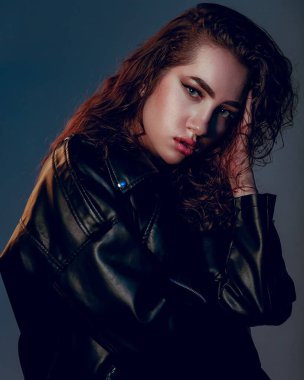 Artı siyah deri ceketli, cüsseli kadın. Güzel kıvrımlı vücut, iç çamaşırlarıyla poz veren baştan çıkarıcı kadın. Koyu mavi stüdyo arka planında duran iç çamaşırlı çekici, iri yarı bir kadın..