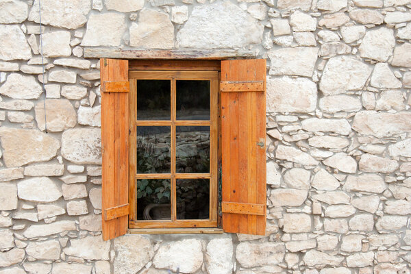 Деревянные окна и ставни в каменной стене
