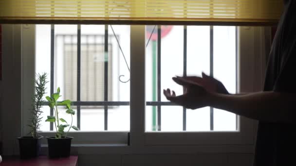 Ugjenkjennelig mann klapper fra vinduet. – stockvideo