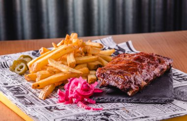Izgara barbekü pirzolası, patates kızartması ve yemeye hazır.