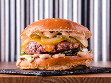 Yemeye hazır lezzetli bir hamburgerin yakın görüntüsü. Hızlı ve sağlıksız bir kavram.