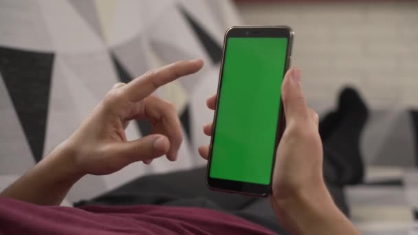 Jonge Man Liggend Bank Staren Naar Zijn Mobiele Telefoon Groen — Stockvideo
