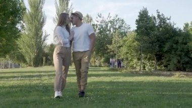 Halk parkında yürüyen genç bir çift. Mutlu Latin adam ve Kafkasyalı aşık kadın