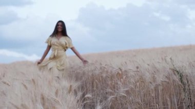 Tarlada yürürken buğdaya dokunan bir kadının ön görüntüsü..