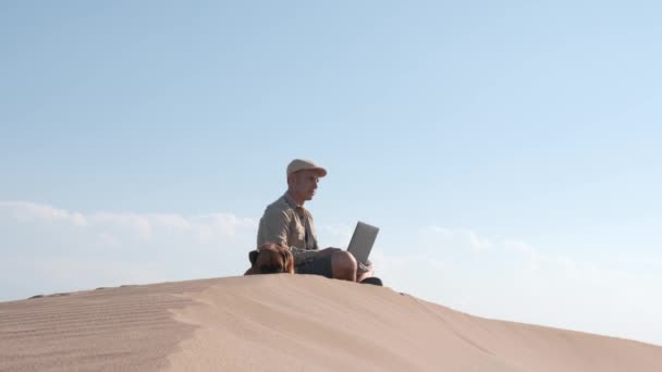 Viaggiatore Maschile Seduto Dune Sabbiose Con Cane Utilizzando Computer Portatile — Video Stock