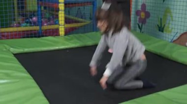 Çocuklar eğlence merkezindeki trambolinlerde zıplıyorlar. Çocuklar oyun alanında eğleniyor.
