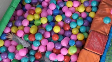 Mutlu çocuklar birlikte oynuyorlar ve renkli toplarla anaokulunda eğleniyorlar. 5-6 yaşlarında.