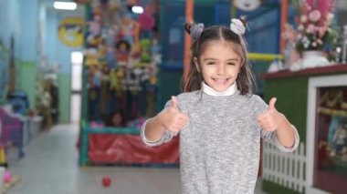 Çocuk parkında gülümseyen 5 yaşında bir kız.