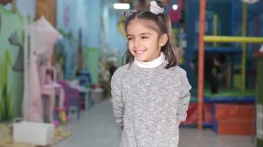 Çocuk parkında gülümseyen 5 yaşında bir kız.