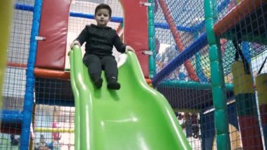 Küçük çocuk eğlence merkezi slayt üzerinde sürme