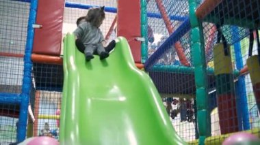 Sevimli mutlu küçük çocuklar renkli taşaklarıyla havuzda kayıyorlar. 5 yaşında. Yavaş çekim