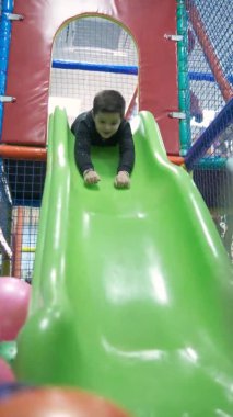 Küçük çocuk eğlence merkezi slayt üzerinde sürme