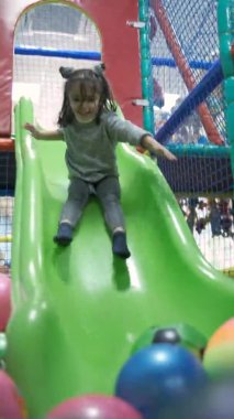 Küçük kız eğlence merkezi slayt üzerinde sürme