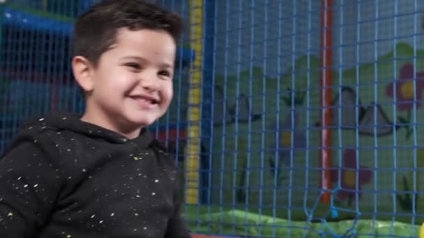 ボールプールに5歳の男の子がボールを投げる幸せ スローモーション — ストック動画
